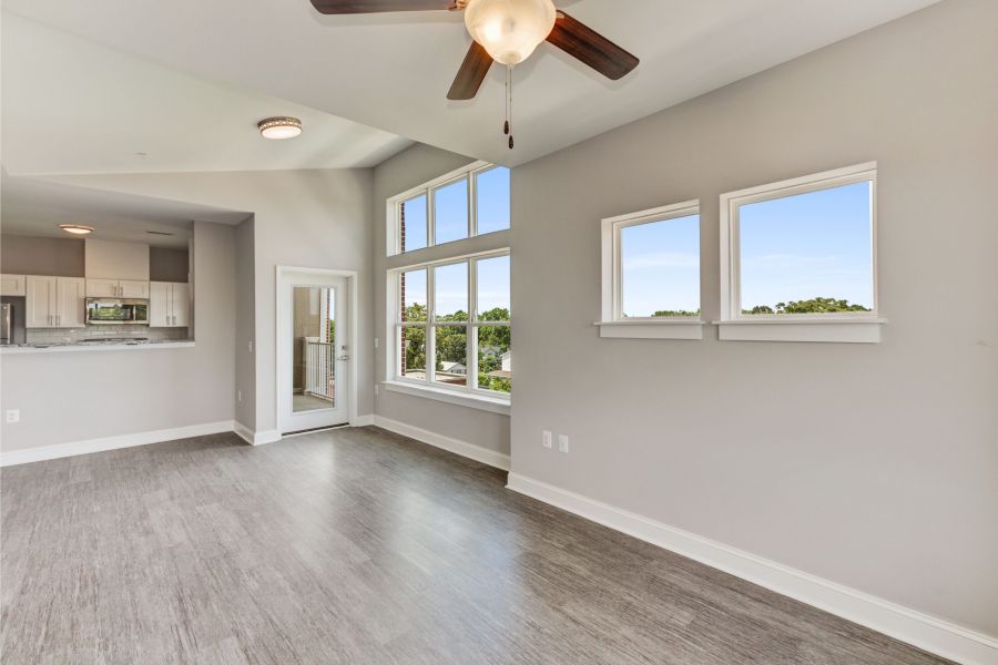 Messenger Place apartment homes with Bright, modern living space with large windows, ceiling fan, and open kitchen in a neutral color palette.