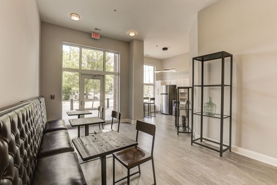 Messenger Place apartment homes with Modern cafe interior with wooden tables, chairs, bench seating, metal shelf, and large windows letting in light.