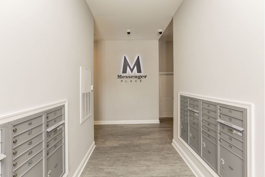 Attain on 5th apartment homes with Hallway with gray mailboxes on both sides and a "Messenger Place" sign on the wall at the end.