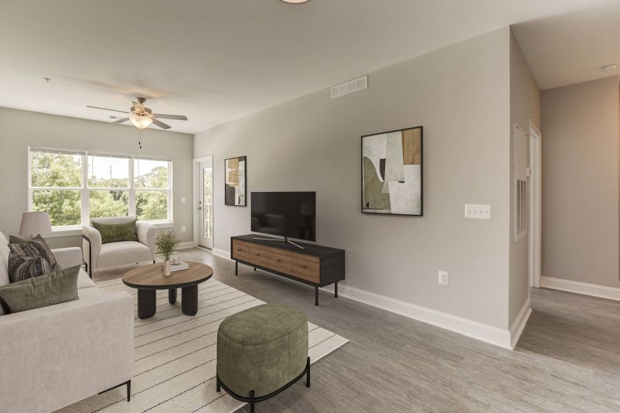 Modern living room with light gray walls, a sofa, armchair, TV, coffee table, large window, and wall art.