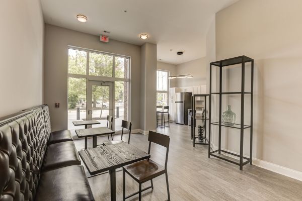 Messenger Place apartment homes with Modern cafe interior with wooden tables, chairs, bench seating, metal shelf, and large windows letting in light.